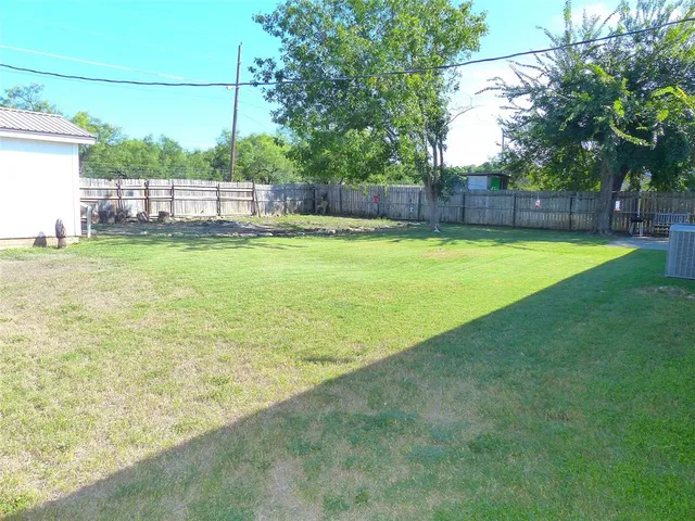 a view of backyard with wooden fence