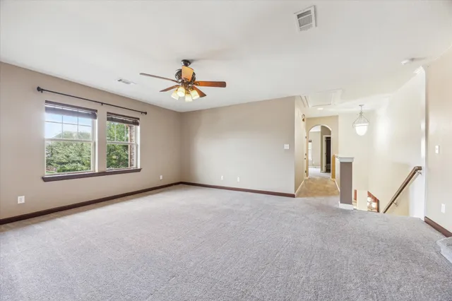 an empty room with a window and a ceiling fan