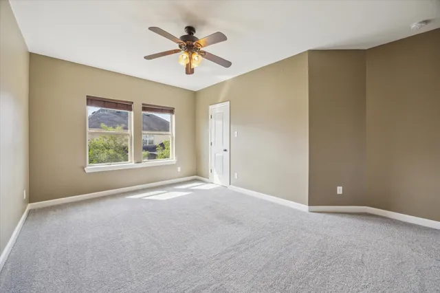 an empty room with a window and a ceiling fan
