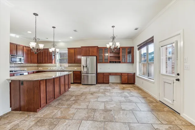 a large kitchen with kitchen island a large counter space a sink appliances and cabinets