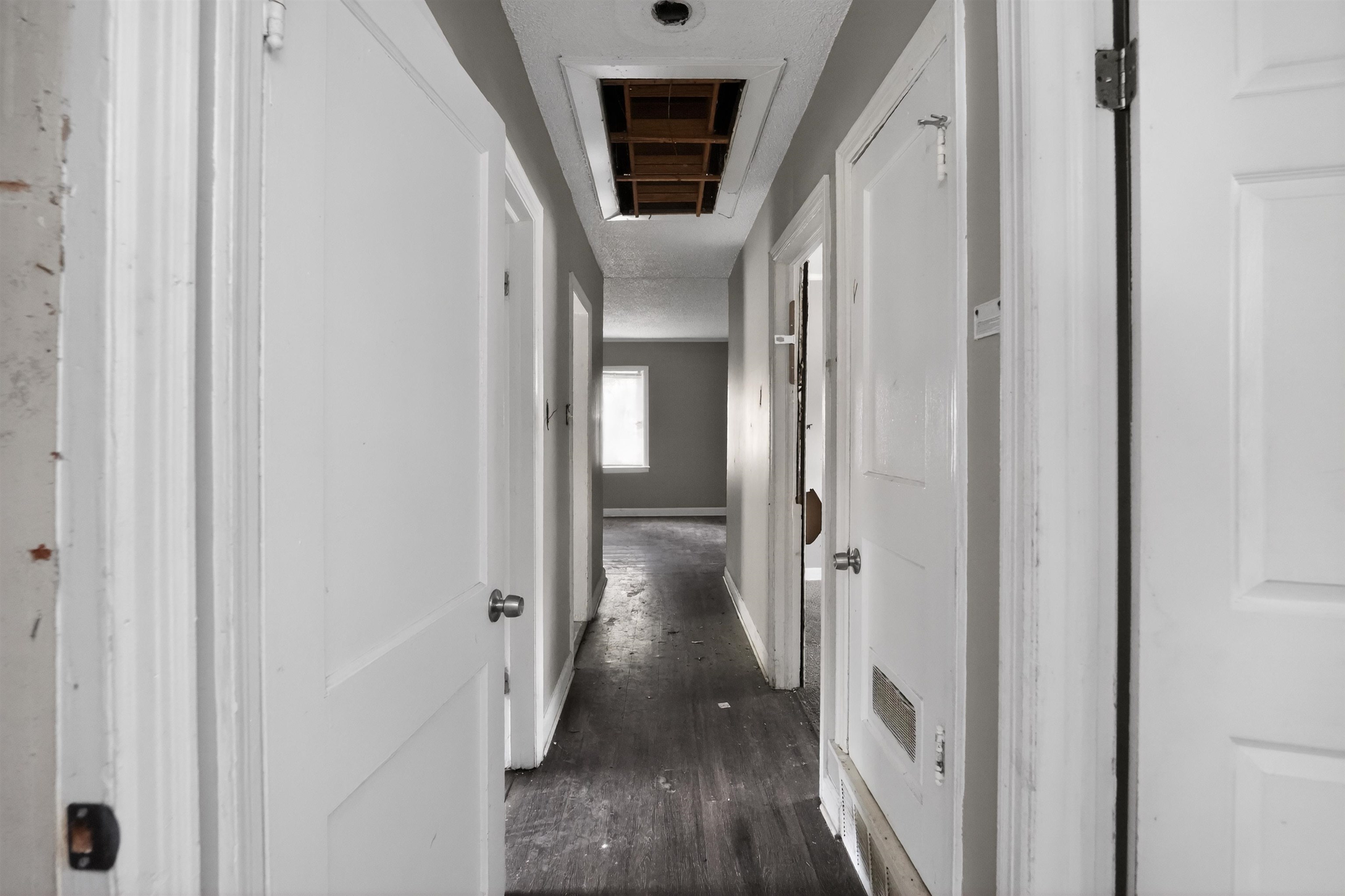 949 Sumter Street Memphis, TN 38122 - Photo 32 of 33 Hallway with multiple interior doors, light-colored walls, and dark wood-finish flooring