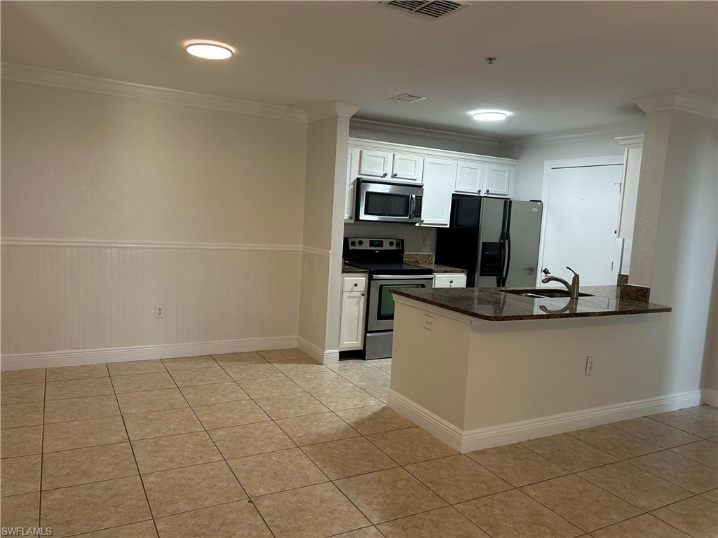 14885 Pleasant Bay Lane, Unit 4104 Naples, FL 34119 - Photo 7 of 17 a kitchen with stainless steel appliances a refrigerator and microwave