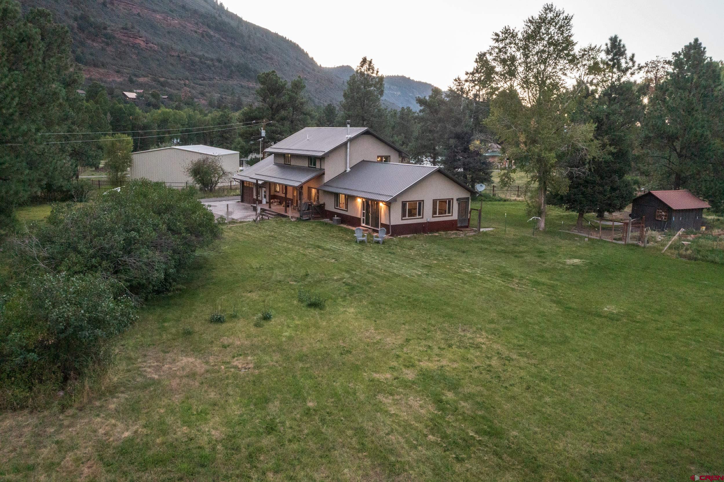 559 Suzanne Lane Ridgway, CO 81432 - Photo 43 of 45 a view of a house with a big yard and large trees
