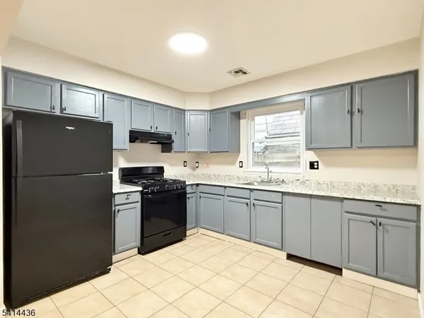 a kitchen with granite countertop stainless steel appliances a refrigerator sink and cabinets