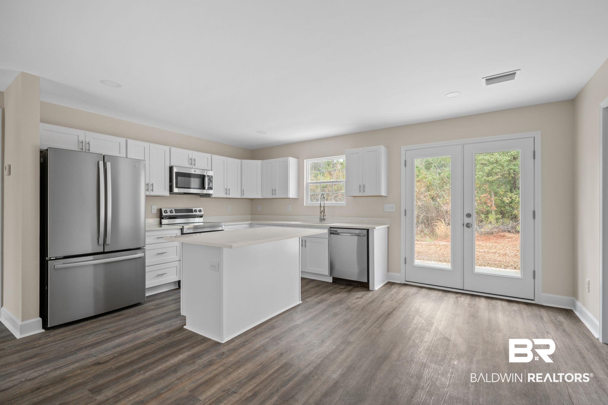 1473 Pollard Road Daphne, AL 36526 - Photo 13 of 32 Kitchen with sink, dark wood-type flooring, white cabinetry, stainless steel appliances, and a center island