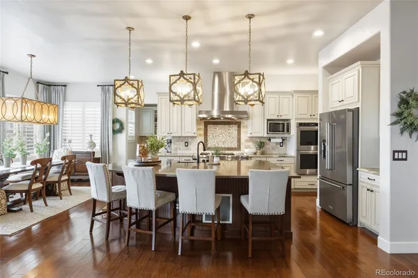 a view of a dining room and livingroom with furniture wooden floor a chandelier