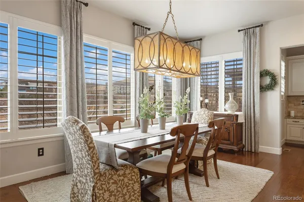 a dining room with furniture a chandelier and wooden floor