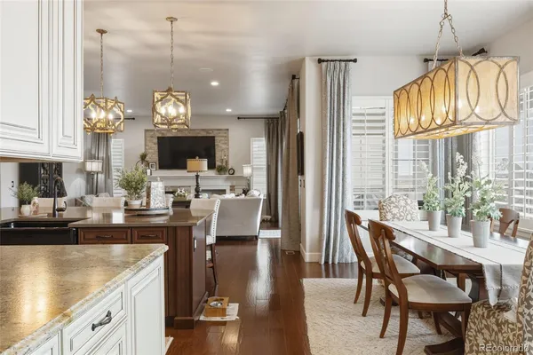 a view of a dining room and livingroom with furniture wooden floor a chandelier