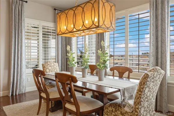 a dining room with furniture and large windows