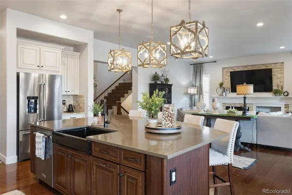 a kitchen with a dining table cabinets stainless steel appliances and wooden floor