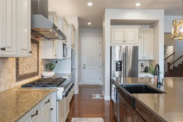 a kitchen with stainless steel appliances granite countertop a sink stove and refrigerator