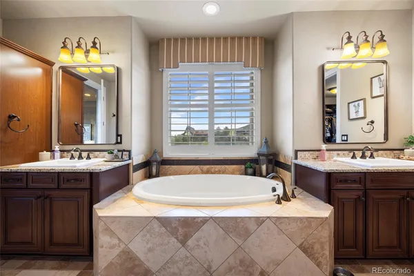 a spacious bathroom with a double vanity sink tub double and mirror