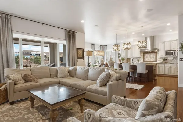 a living room with furniture kitchen view and a large window