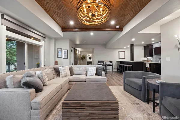 a living room with furniture a chandelier and a large window