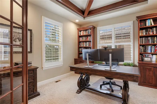 a view of a workspace with furniture and a window