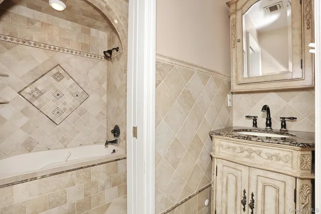 a bathroom with a granite countertop sink a vanity and shower