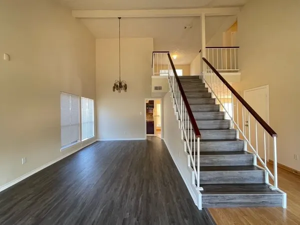 a view of staircase with wooden floor and white walls