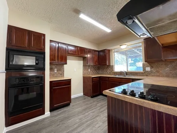 a kitchen with granite countertop wooden cabinets and stainless steel appliances