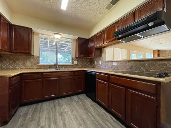 a kitchen with stainless steel appliances granite countertop wooden cabinets a sink and dishwasher