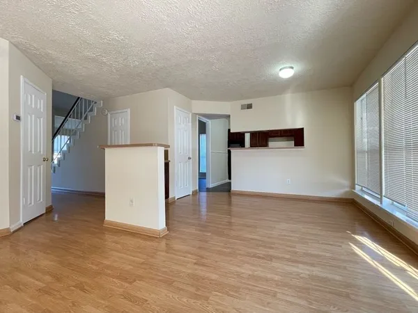 a view of empty room with wooden floor