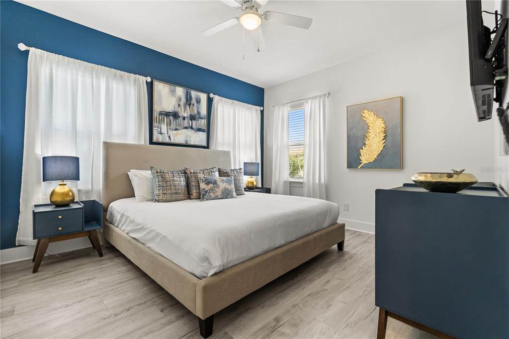 7456 Gathering Drive Reunion, FL 34747 - Photo 20 of 49 a bedroom with a large bed and a chandelier