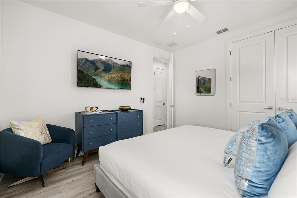 7456 Gathering Drive Reunion, FL 34747 - Photo 21 of 49 a bedroom with a bed and a flat screen tv
