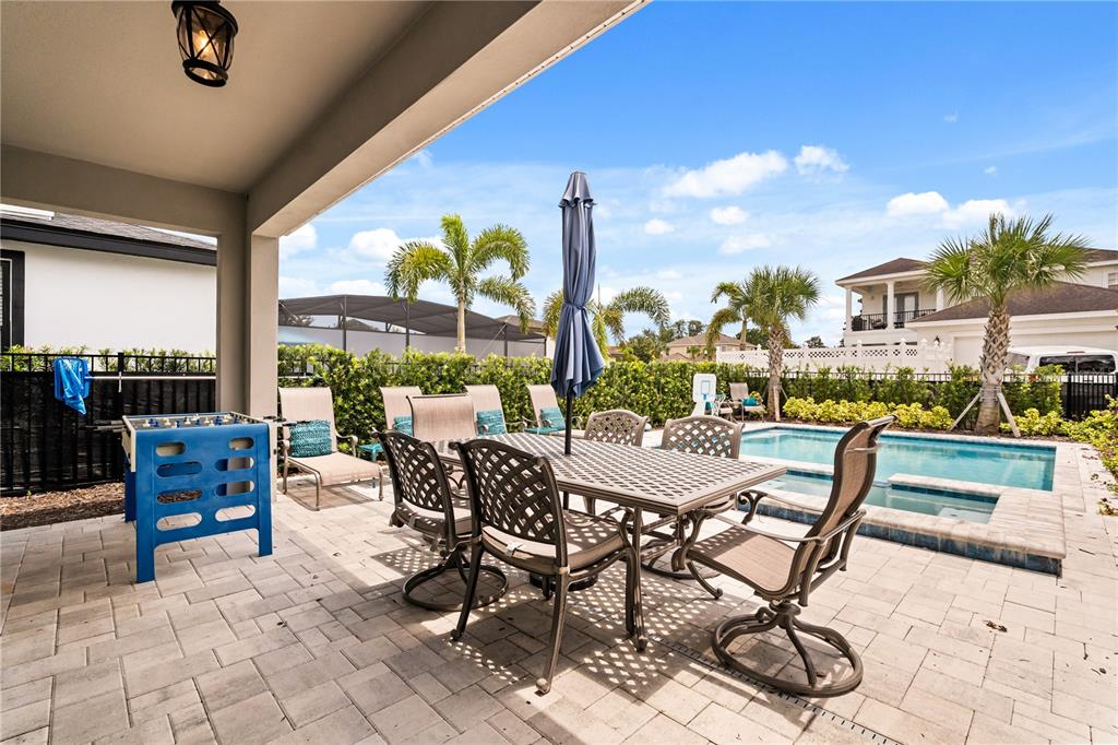 7456 Gathering Drive Reunion, FL 34747 - Photo 37 of 49 a view of a patio with dining table and chairs with a barbeque grill and a fireplace