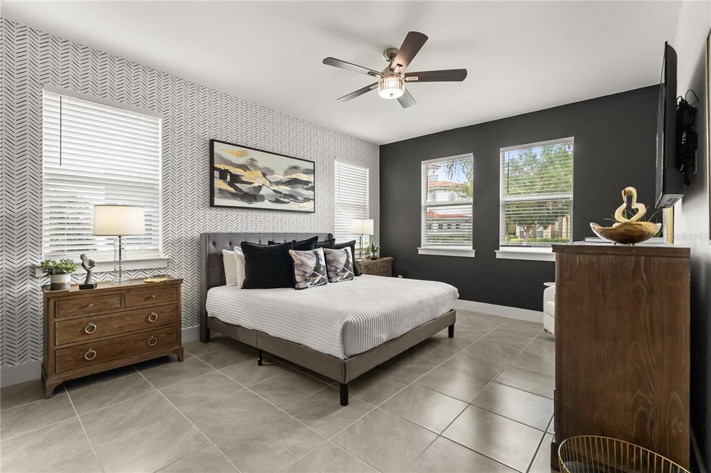 7456 Gathering Drive Reunion, FL 34747 - Photo 10 of 49 a spacious bedroom with a bed a dresser and large window
