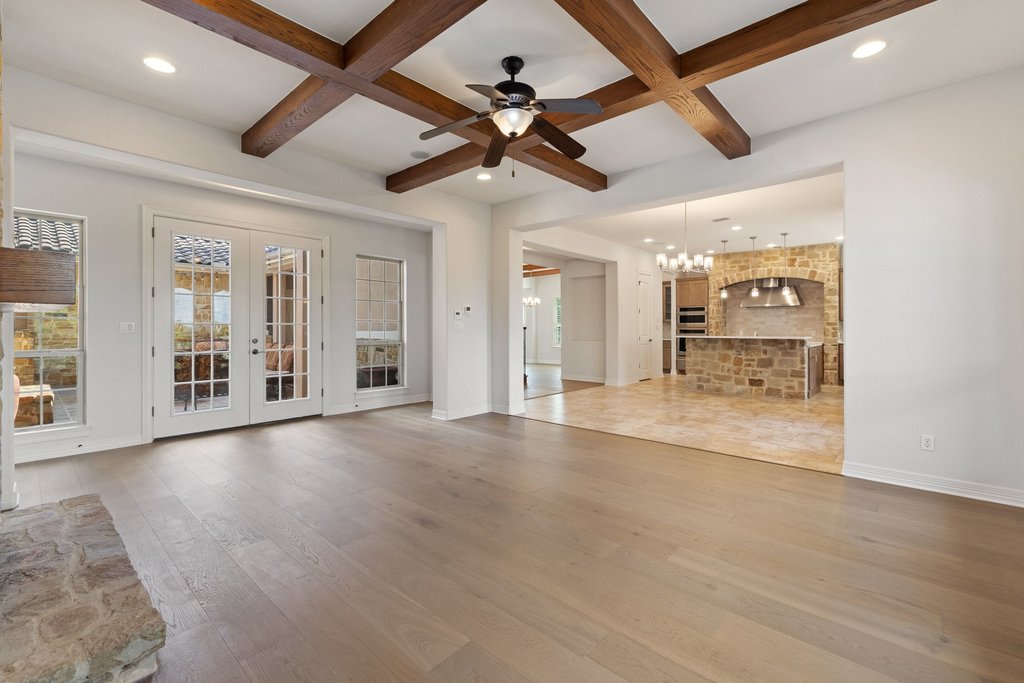 109 Largo Cove Austin, TX 78734 - Photo 16 of 40 Exposed wood beams adorn the high ceilings, creating an inviting space with rich architectural detail.