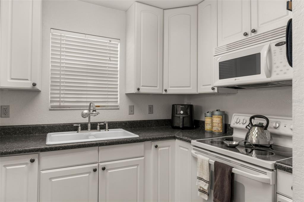 5890 South Mason Creek Road Homosassa, FL 34448 - Photo 17 of 50 a kitchen with stainless steel appliances granite countertop white cabinets a sink and dishwasher