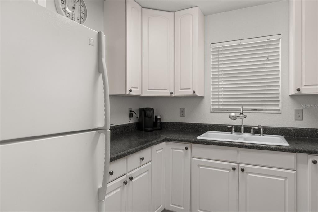 5890 South Mason Creek Road Homosassa, FL 34448 - Photo 18 of 50 a kitchen with granite countertop white cabinets and a sink