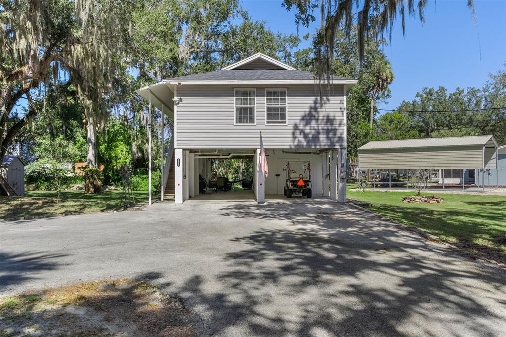 5890 South Mason Creek Road Homosassa, FL 34448 - Photo 2 of 50 a front view of a house with a garden and trees