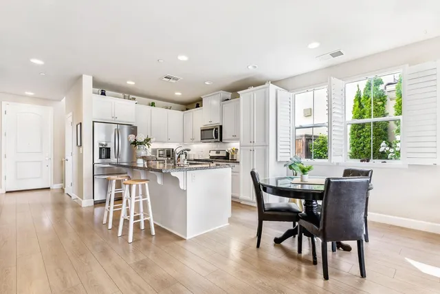 a kitchen with a dining table chairs appliances and cabinets