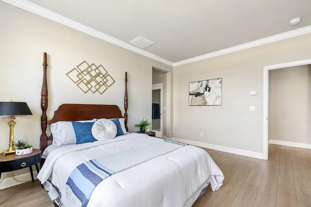 a bedroom with a bed and wooden floor