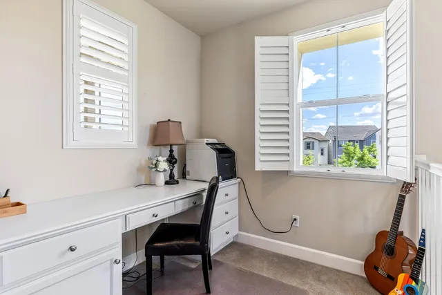 a view of a workspace with furniture and a window