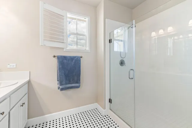 a bathroom with a shower a sink and a window