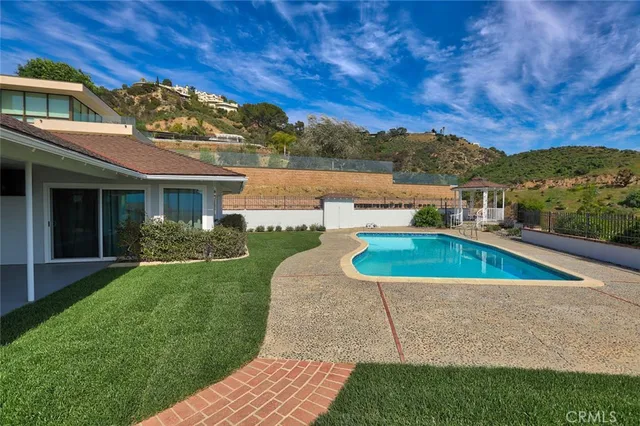 a view of a house with pool and a yard