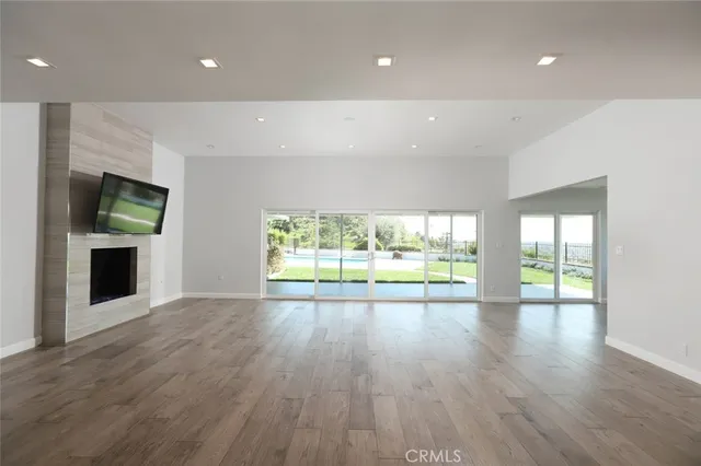 an empty room with wooden floor and a fireplace