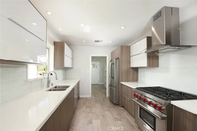 a kitchen with stainless steel appliances a sink stove and cabinets