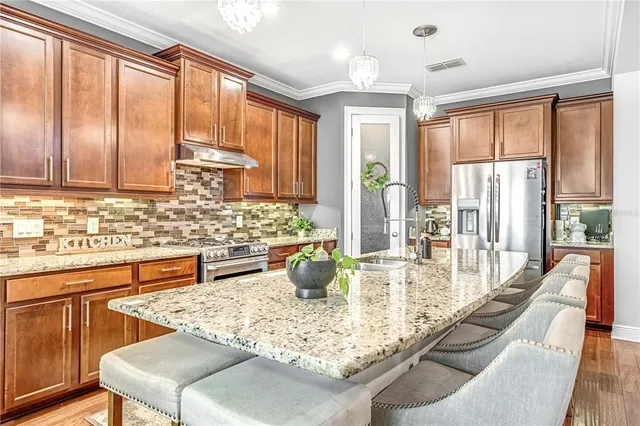 a large kitchen with kitchen island granite countertop a large window and chairs