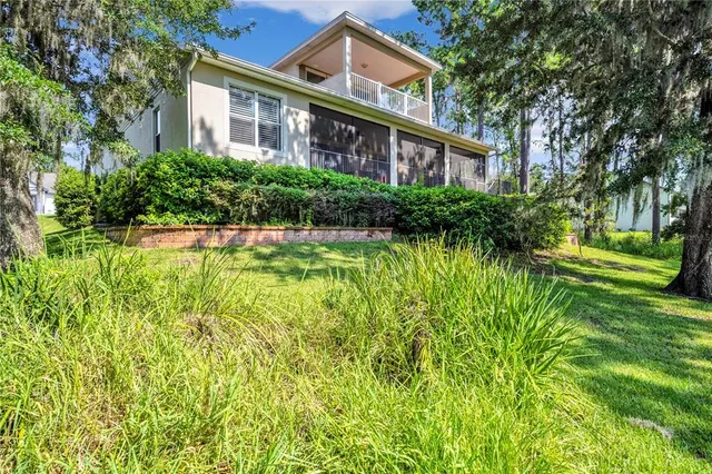 a front view of a house with a garden and fountain