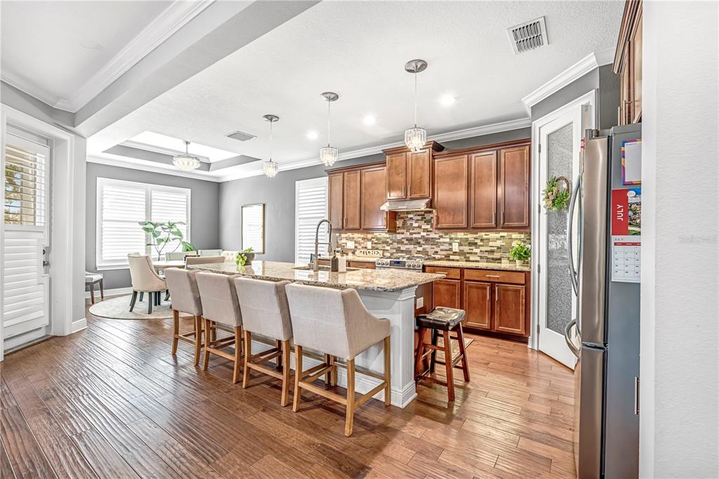 4081 Southern Valley Loop Brooksville, FL 34601 - Photo 6 of 64 a dining room with stainless steel appliances kitchen island granite countertop a dining table chairs and view living room