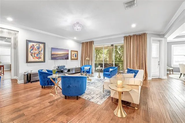 a living room with furniture large window and wooden floor