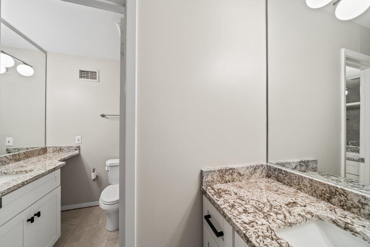 760 Roland Street Memphis, TN 38104 - Photo 18 of 29 a bathroom with a granite countertop sink a toilet and a mirror
