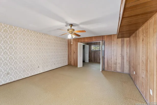 a view of a room with a ceiling fan and window