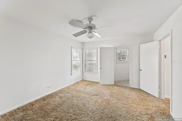 a view of an empty room with a ceiling fan