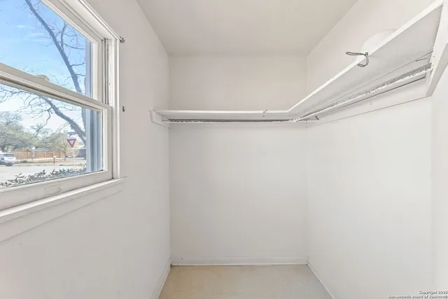 a view of a small space with wooden floor and a window