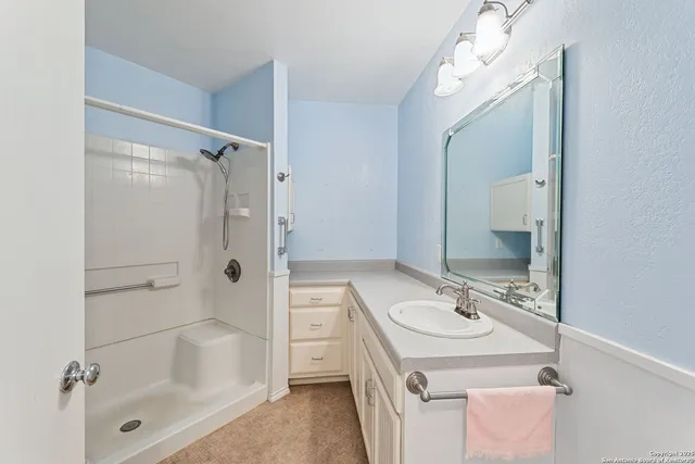 a bathroom with a bath tub sink mirror and shower