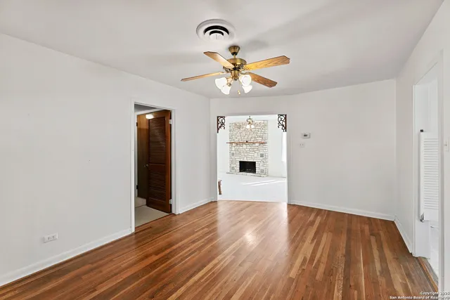 a view of a room with wooden floor and a ceiling fan