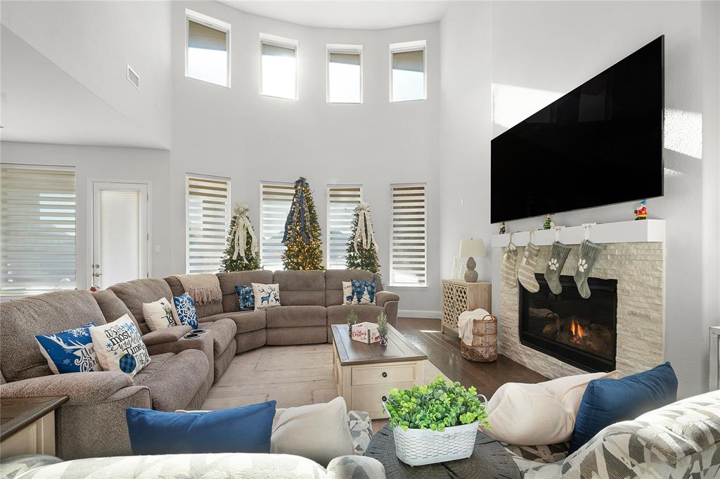 1510 Chisholm Trail Prosper, TX 75078 - Photo 1 of 32 a living room with furniture a fireplace and a flat screen tv